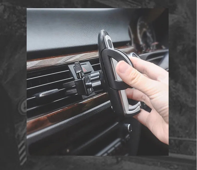Black plastic mobile phone holder attached to a car air conditioning vent.