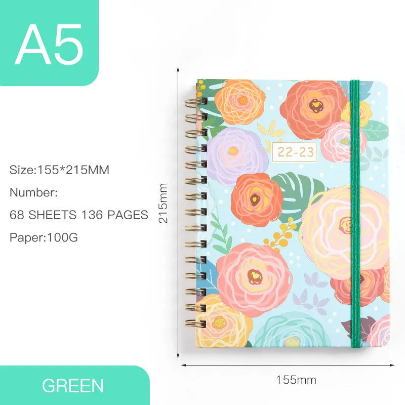 A5 spiral coil notebook open showing annual calendar pages and spiral binding