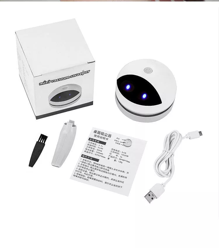 Compact USB charging wireless mini portable robot desktop vacuum cleaner on a desk