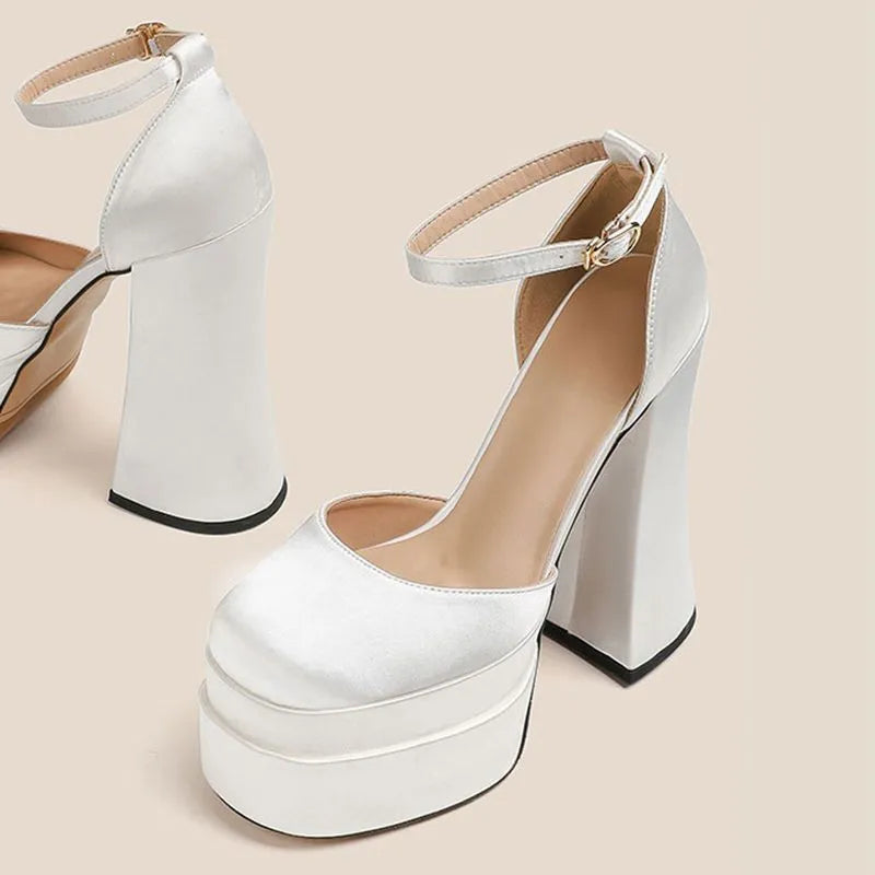 Women's white chunky heel platform pumps with a round toe and mid-calf cut.