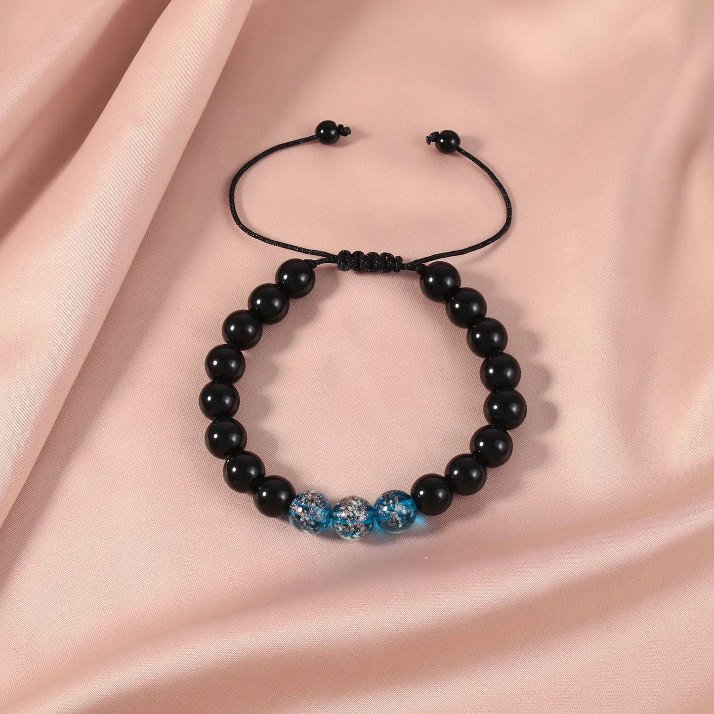 Adjustable bracelet with luminous geometric glass beads in six colour options on a wrist
