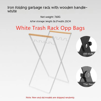 Black iron folding trash rack with wooden handles mounted on a wall holding a recycling bag.