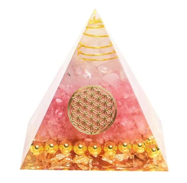 A small 6cm clear epoxy resin pyramid ornament containing pieces of natural crystal gravel on a flat surface.