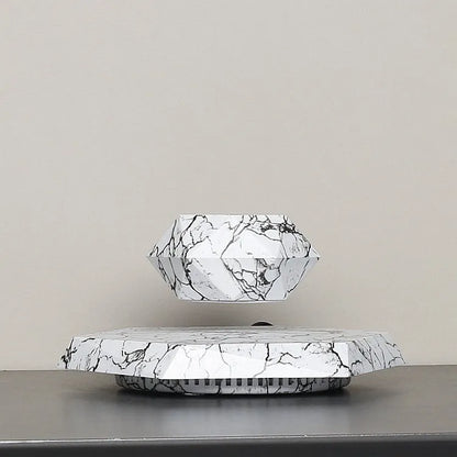 Marbling colour magnetic levitating plant pot floating above base with small plant inside