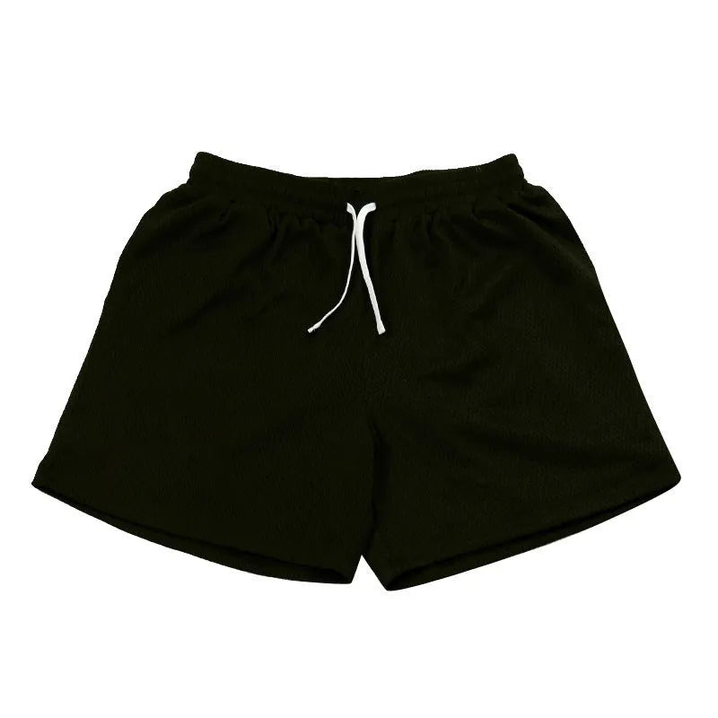 Men's black athletic shorts with grey mesh side panels for breathability, laid flat on a surface.