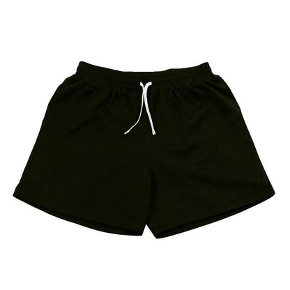 Men's black athletic shorts with grey mesh side panels for breathability, laid flat on a surface.