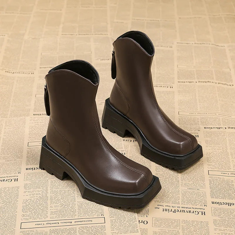 Women's black platform Martin ankle boots with square toe and back zip on a white background.