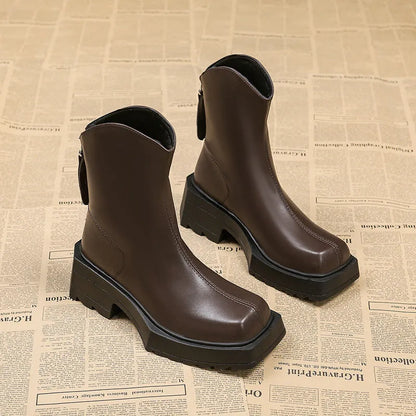 Women's black platform Martin ankle boots with square toe and back zip on a white background.