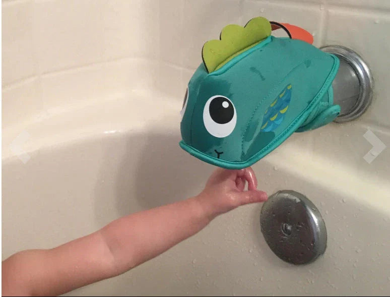 Soft, water-resistant cloth bath faucet cover in a whale design to protect baby's head during bath time