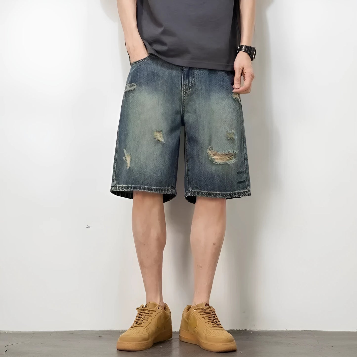 Men's blue distressed denim shorts with loose hole detailing and straight leg cut