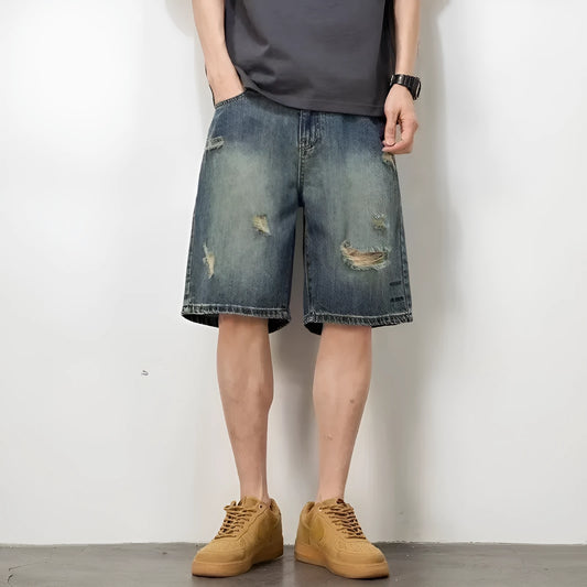 Men's blue distressed denim shorts with loose hole detailing and straight leg cut
