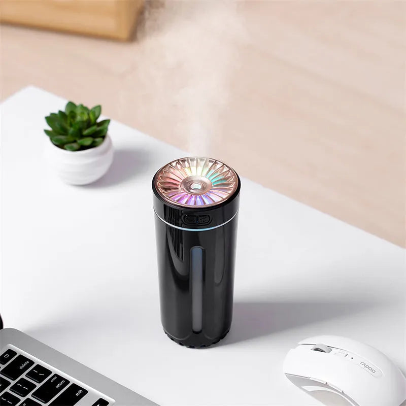 Black wireless car humidifier with colourful LED lights shown in vehicle cup holder