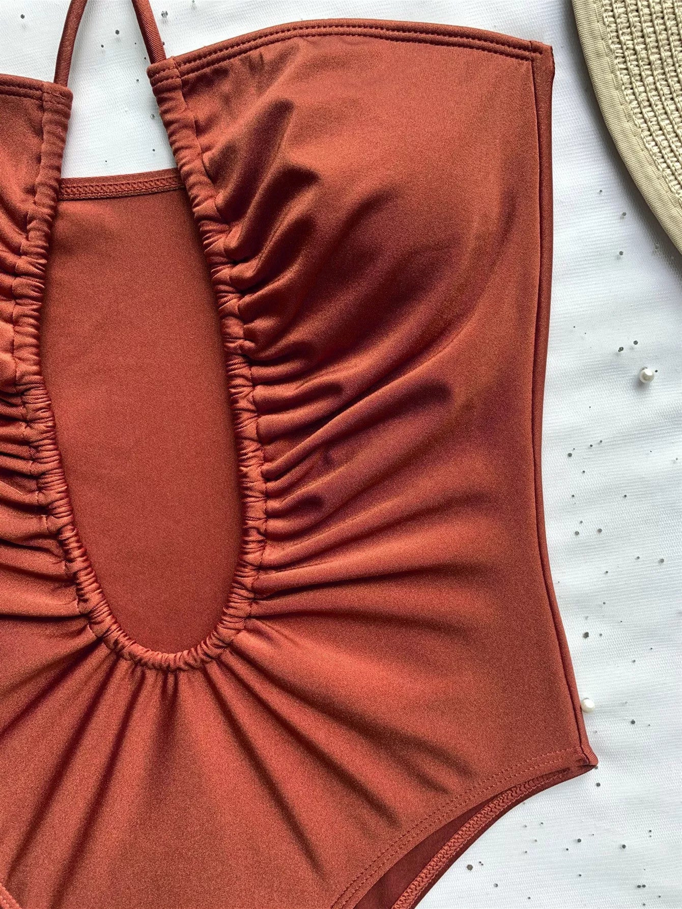 Women's solid color one-piece swimsuit with adjustable strap in brown, black, and rose red