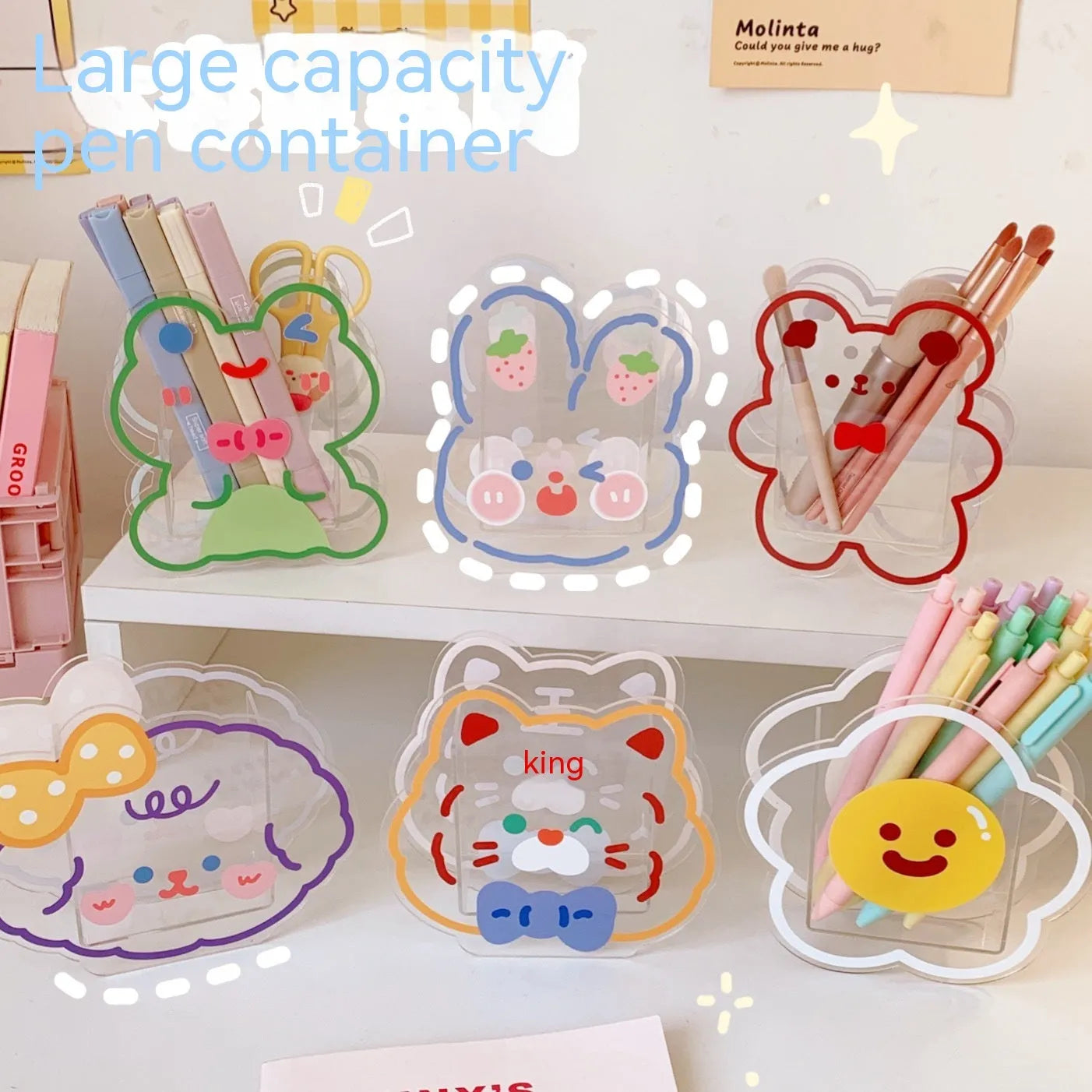 Square transparent acrylic storage box with printed character theme containing coloured pens
