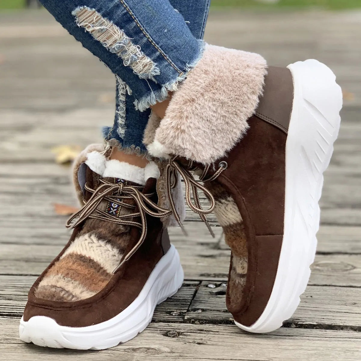 Women's lace-up snow boots in beige with suede upper, thermal fur lining, and non-slip rubber sole on a winter background