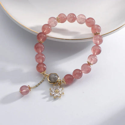 A Mori style crystal bracelet made with natural pink strawberry quartz stones and delicate electroplated floral charms.