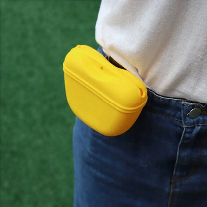 Black silicone dog training treat pouch with clip and magnetic closure shown attached to a belt.