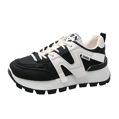 White low-top unisex sneaker with round toe and flat rubber sole on a plain background.