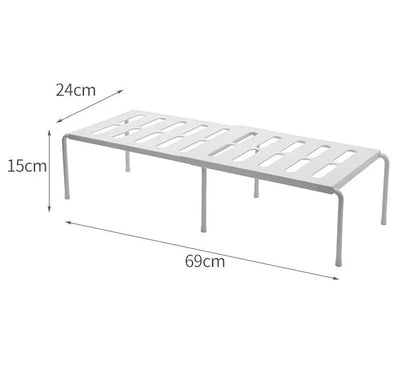 White telescopic kitchen storage rack at adjustable height on a countertop