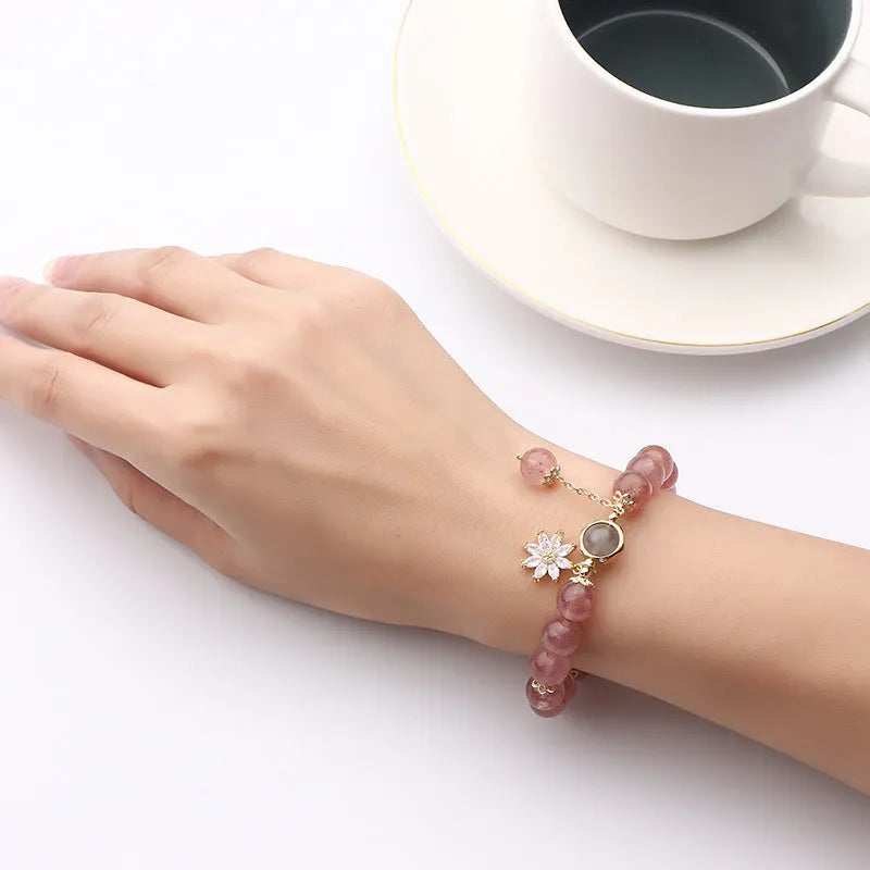 A Mori style crystal bracelet made with natural pink strawberry quartz stones and delicate electroplated floral charms.