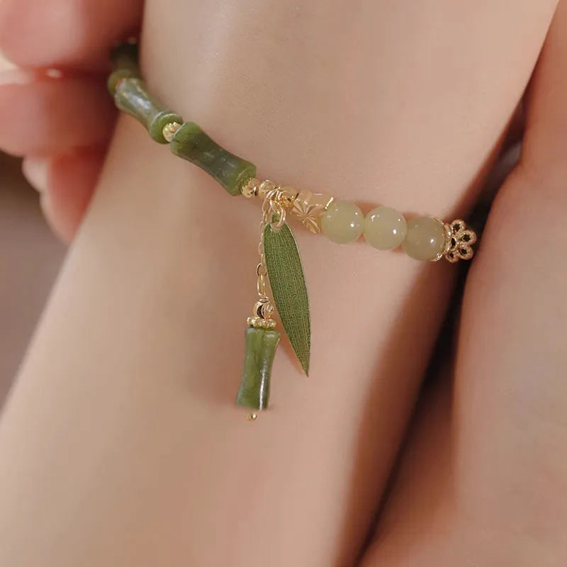 Chinese style glass bead bracelet with bamboo joint design on wrist.