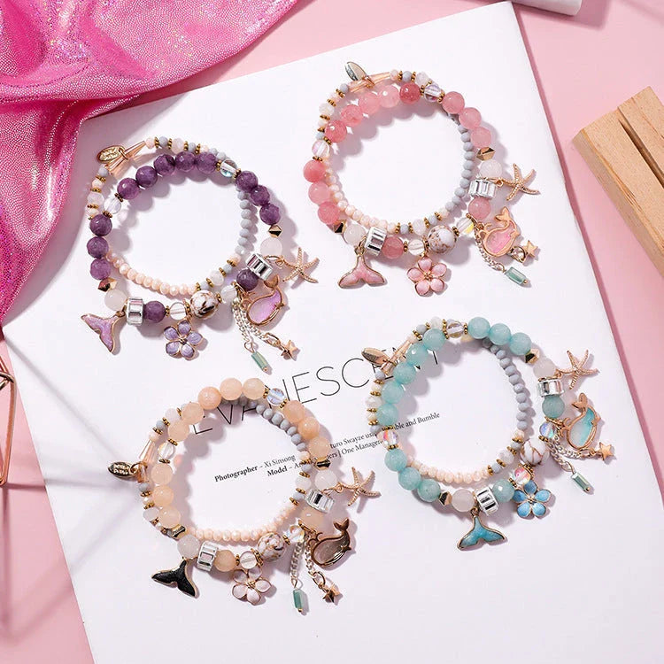 Elegant whale tail bracelet in vibrant colors with flower and starfish accents, perfect for adding a touch of coastal charm to any outfit.