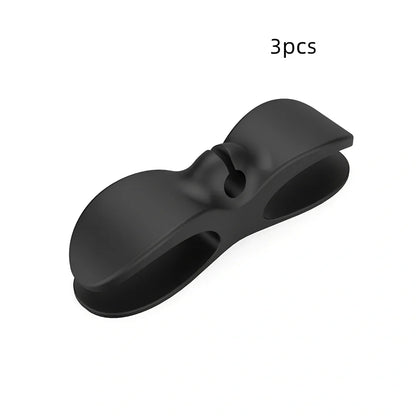 Black TPU cable organizer clips winding appliance cords on kitchen counter, 5cm size, non-marking adhesive for tidy management