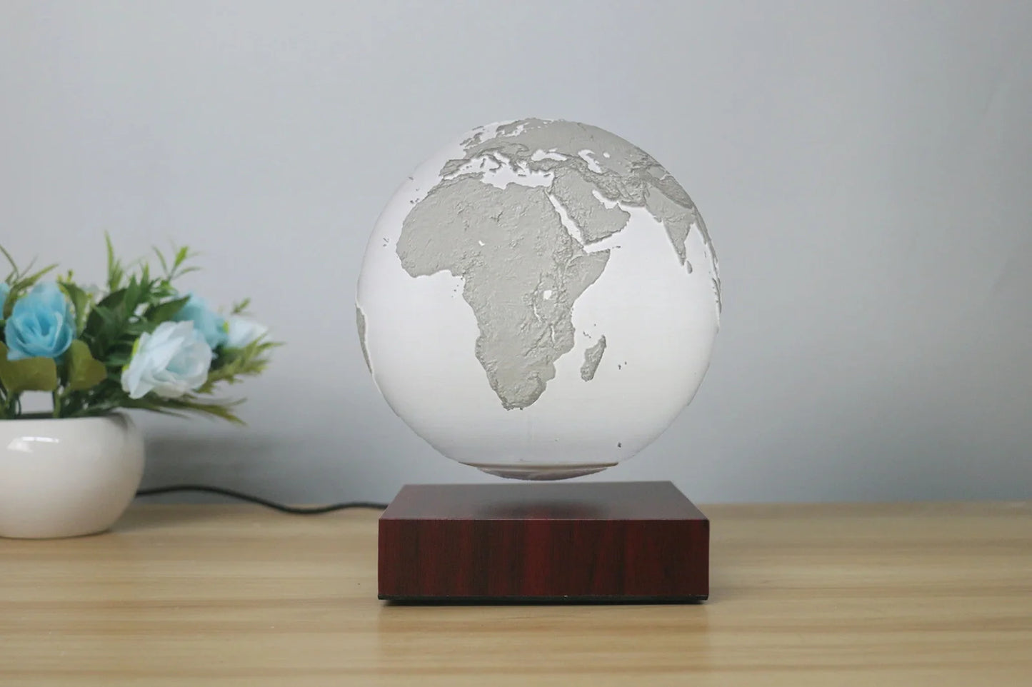 Levitating Earth or Jupiter lamp floating above base with LED illumination