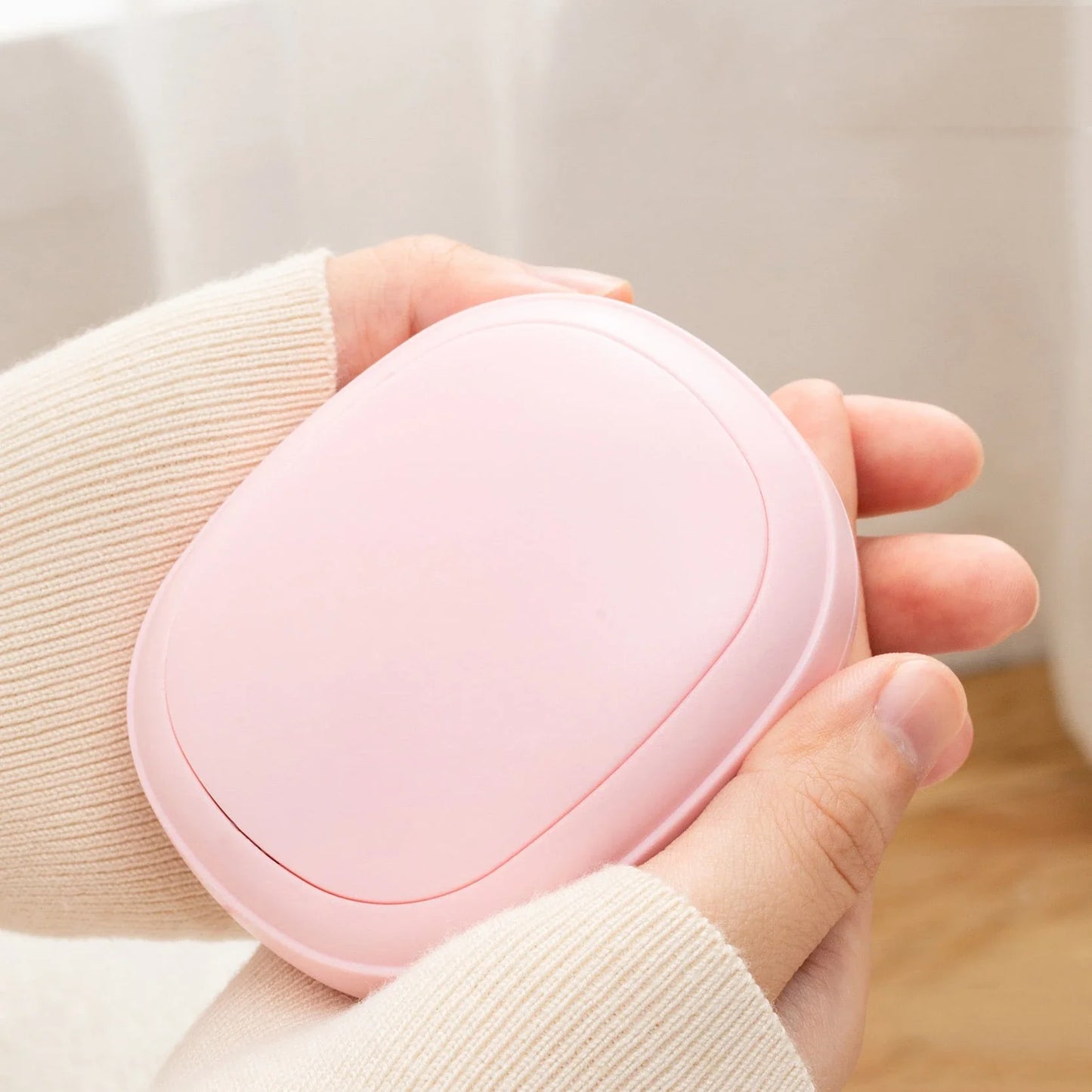 Compact, pebble-shaped hand warmer with adjustable heating settings, available in multiple colors