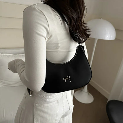 Women's silver dumpling-shaped PU crossbody bag showing front sandwich pocket and single shoulder strap.