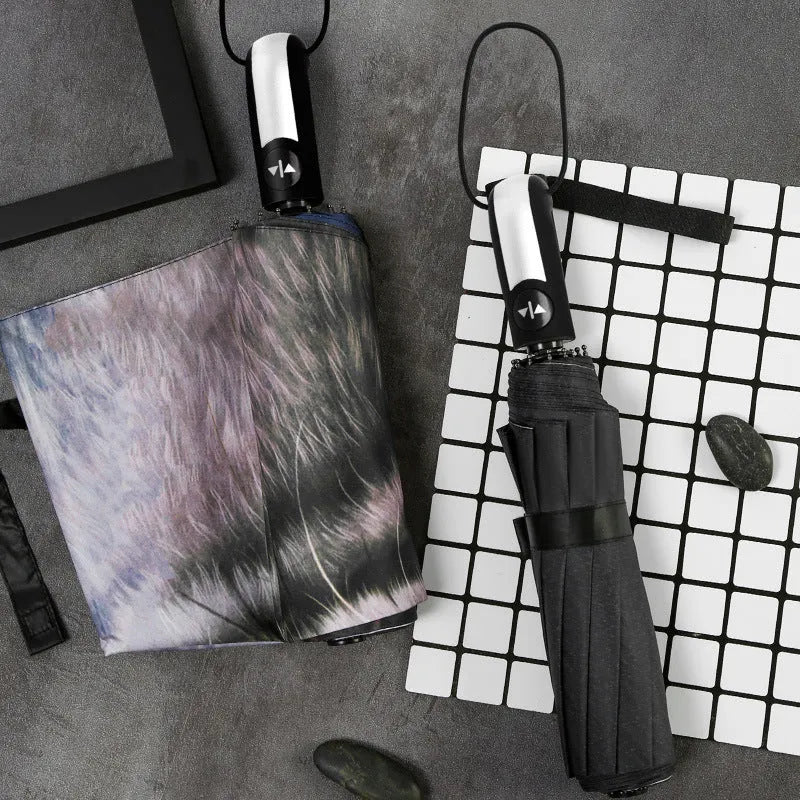 Folding umbrella showing tri-fold design with gesture motif and plastic handle