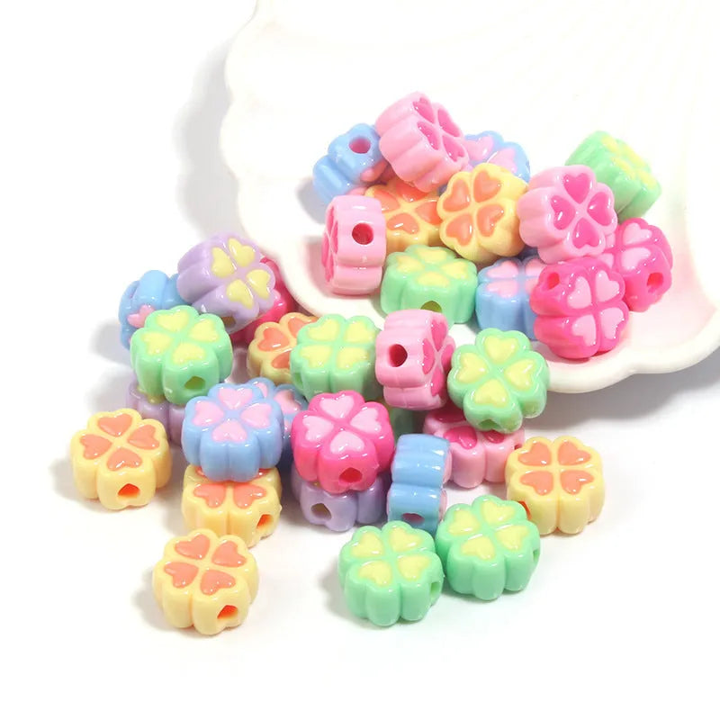 Assorted frosted acrylic four-leaf clover shaped beads in pink, green, and yellow, 15mm diameter.