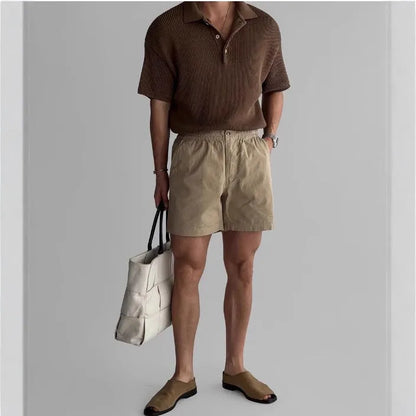 Men's loose-fit cotton sports shorts in black, shown on a hanger
