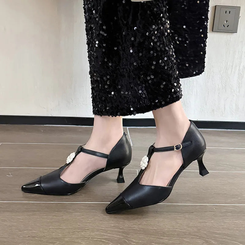 Women's black pointed toe stiletto heel shoes with floral buckle on sheepskin upper.