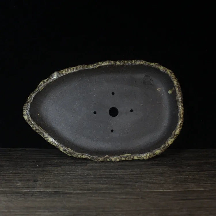 Handmade purple clay flower pot with unique shape showing natural ceramic texture