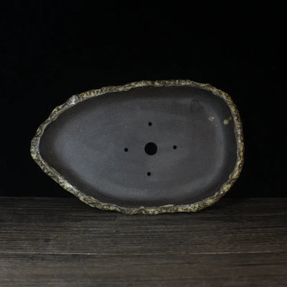 Handmade purple clay flower pot with unique shape showing natural ceramic texture