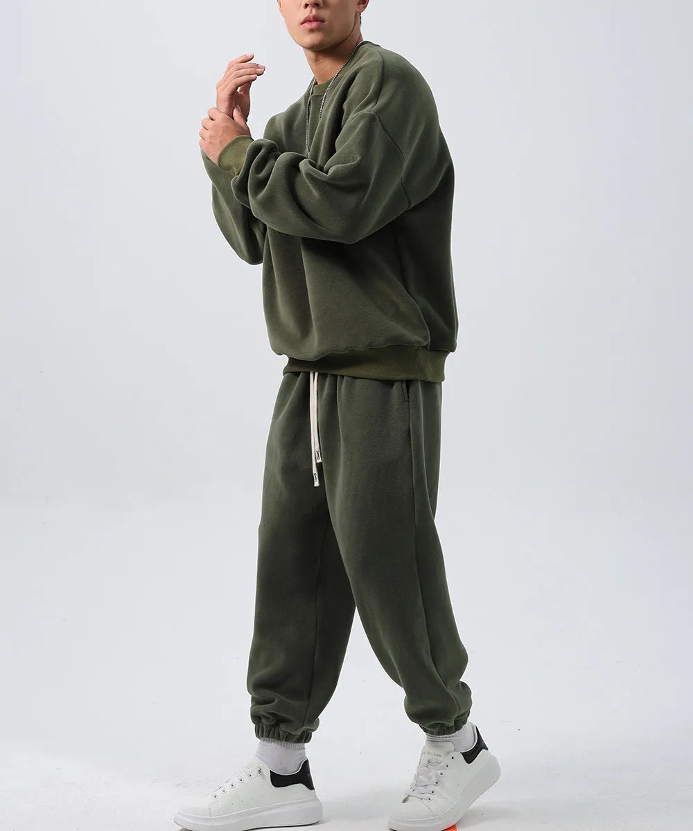 Man wearing a two-piece army green polar fleece suit with crew neck top and padded trousers.