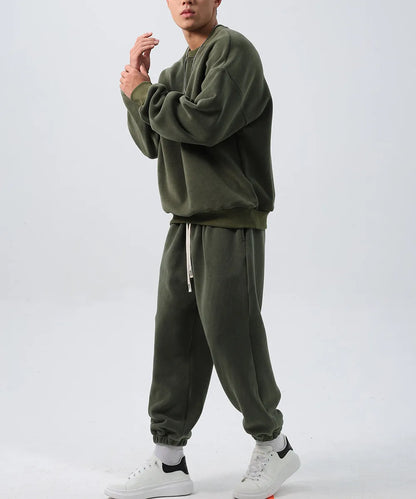 Man wearing a two-piece army green polar fleece suit with crew neck top and padded trousers.