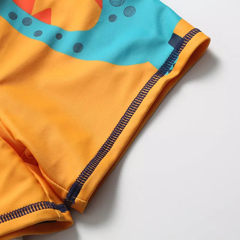 Cartoon dinosaur swimming trunks for boys in light blue, dark blue, and orange