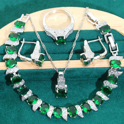 Four-piece bridal jewellery set with zircon pendants on a water wave chain, showing necklace, bracelet, earrings and ring.