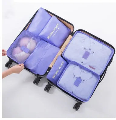 Set of six coloured nylon packing cubes and flat pouches for travel organisation.
