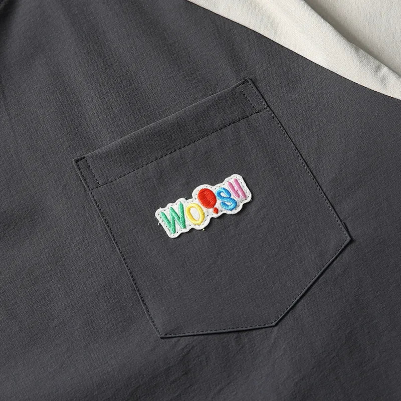 Dark grey loose fit men's t-shirt with contrast colour raglan sleeves on a hanger.