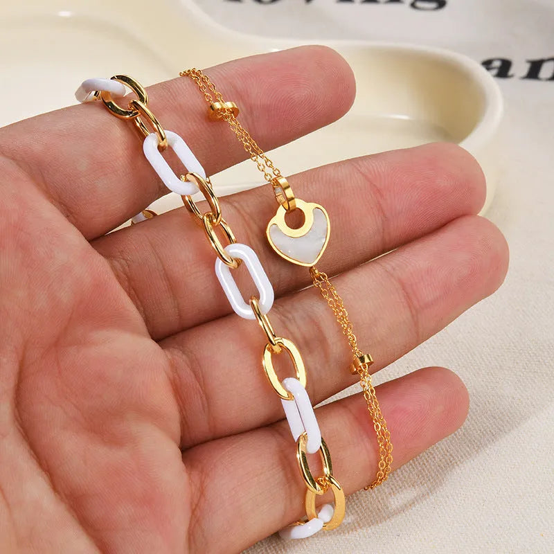 Stainless steel bracelet with double-layer heart design containing resin elements, shown on wrist
