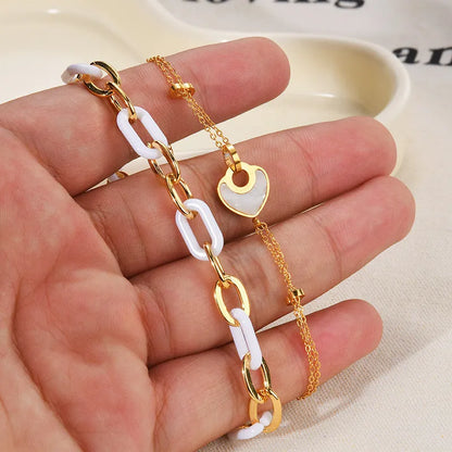 Stainless steel bracelet with double-layer heart design containing resin elements, shown on wrist