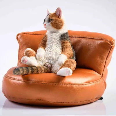 Lazy cat ornament on miniature sofa for car dashboard decoration, 7.5cm high with fabric art detailing