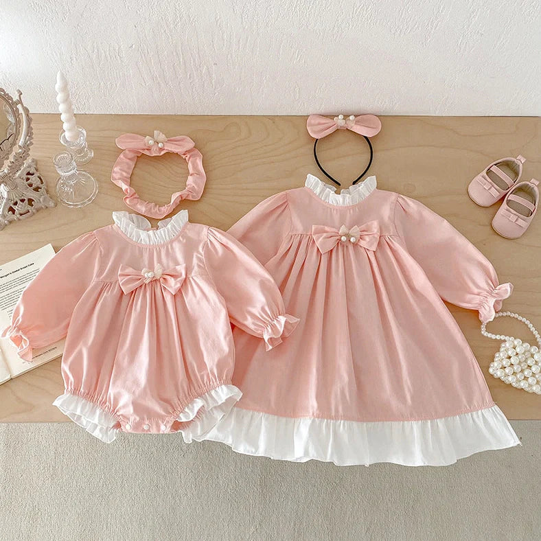 Girl wearing peach branch climbing colour triangle jumpsuit with princess dress styling and matching headband