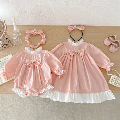 Girl wearing peach branch climbing colour triangle jumpsuit with princess dress styling and matching headband