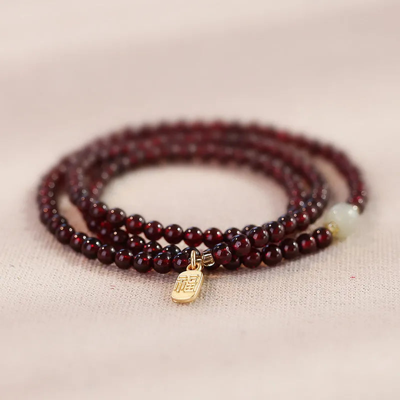 Handmade antique Chinese style bracelet with red imitation garnet and pomegranate design in a gift box.