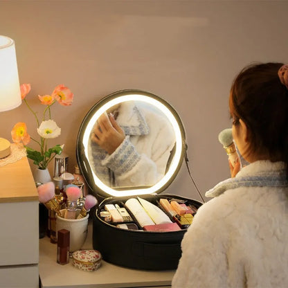 Round black LED light makeup bag with built-in mirror, carry strap, and open compartment showing internal partitions.