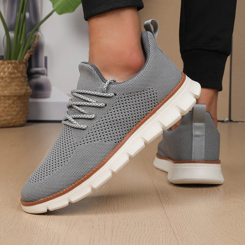 Men's casual low-top sneakers in breathable mesh fabric with a shallow cut and round toe, available in grey and black colourways with sizes from UK 6 to UK 13 for youth to adult men.